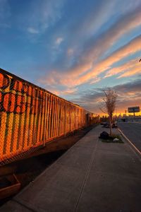 Road by bridge against sky during sunset
