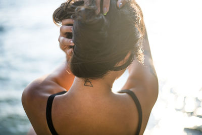 Young latina woman relaxing by the ocean at golden hour in summertime