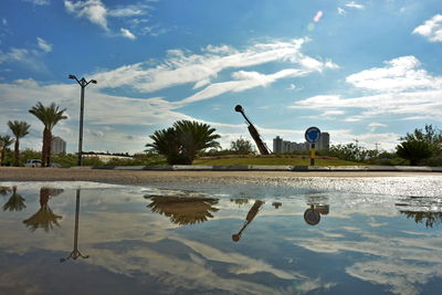 Reflection of man in lake against sky