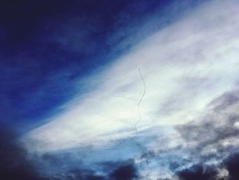 Low angle view of birds flying against blue sky