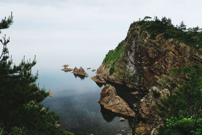 Rock formations by sea against sky