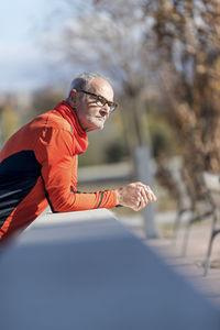 Side view of man standing against trees