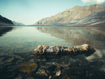 Scenic view of lake by mountains against sky