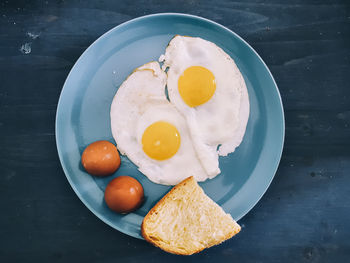 High angle view of fried eggs in plate on table