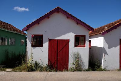 Houses by footpath against sky