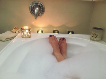 Low section of woman in bathtub