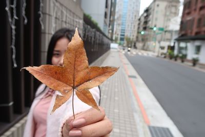 Close-up of woman holding umbrella on street