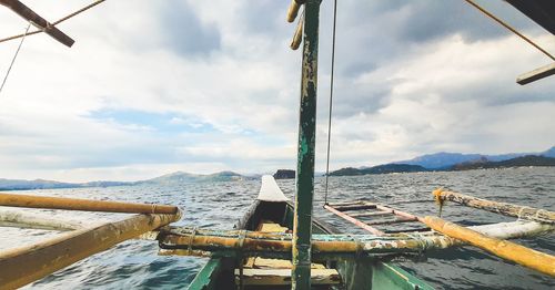 Reflection of man on boat in sea against sky