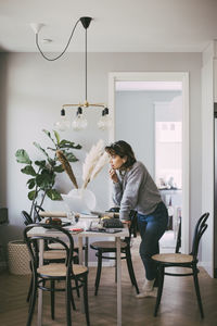 Thoughtful woman talking on the phone in home office