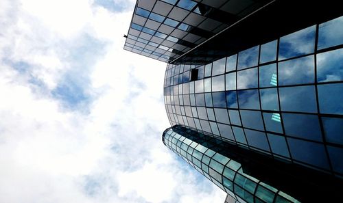 Low angle view of modern building against cloudy sky