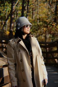 Woman wearing warm clothing while looking away in park during autumn