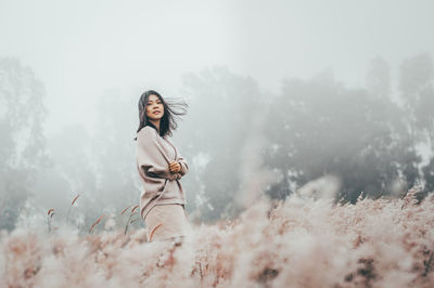 Portrait of woman standing against sky