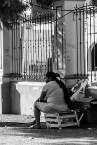 Side view of a woman sitting on bench