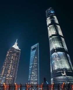 Low angle view of illuminated buildings against sky at night