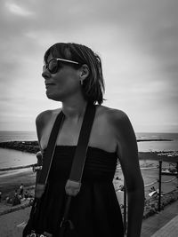 Woman in sunglasses standing at beach