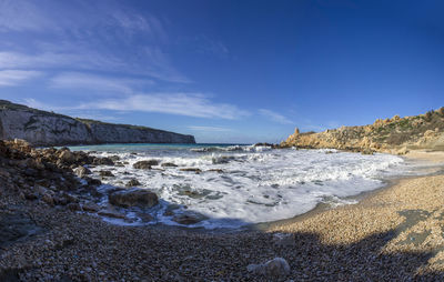 Scenic view of beach against blue sky