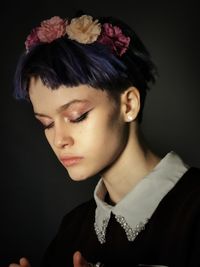 Portrait of beautiful young woman against black background