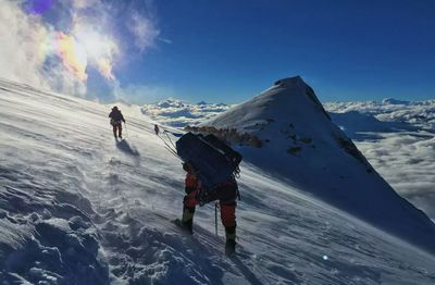 People walking on snowcapped mountain