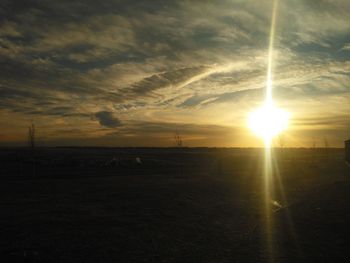 Scenic view of silhouette field against sky during sunset