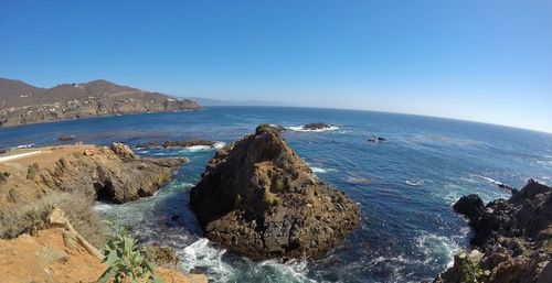 Panoramic view of calm sea against clear blue sky