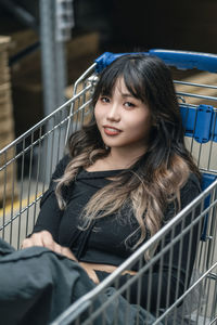 Portrait of smiling young woman sitting in shopping mall