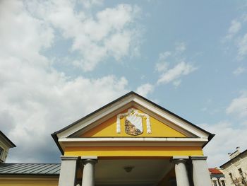 Low angle view of yellow building against sky