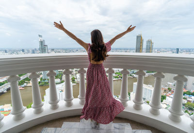 Rear view of woman standing on balcony