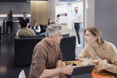 Two professionals working together in office cafeteria