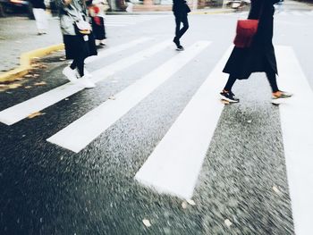 Low section of man walking on wet road