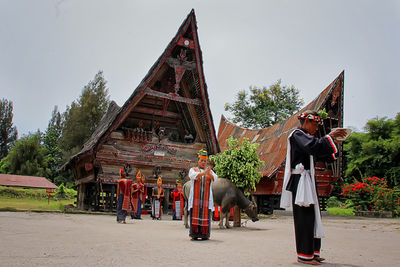 Rear view of people at temple against sky