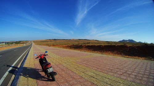 Man riding horse on farm against sky