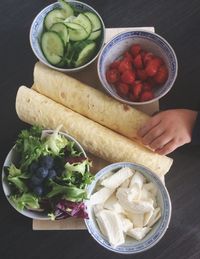 Close-up of hand holding vegetables in bowl