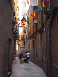 People walking on narrow street amidst buildings