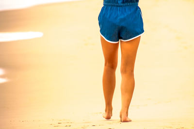 Low section of child standing on beach