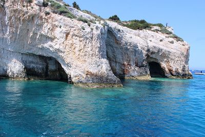 Rock formation in sea against sky