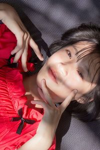 High angle portrait of woman lying down on bed