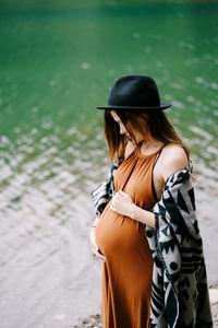 Pregnant woman standing by lake