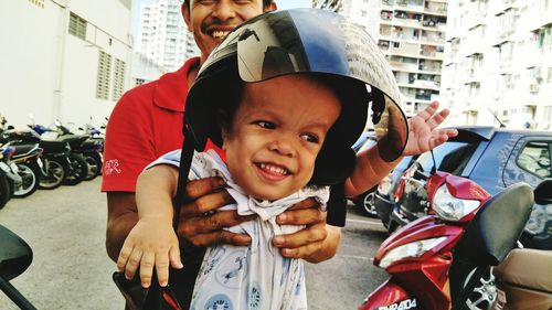 Smiling father carrying son wearing helmet