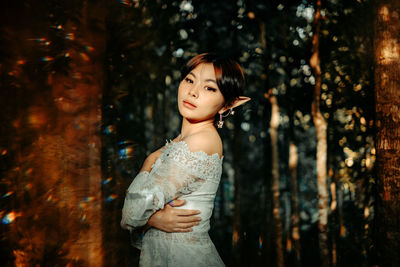 Side view of woman standing on tree trunk