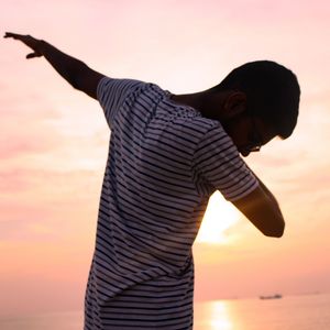 Midsection of man standing against sky during sunset