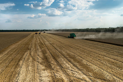 Agricultural machinery on field against sky