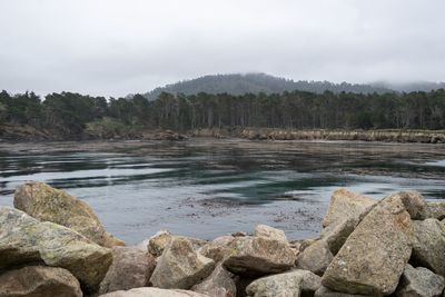 Scenic view of rocks by lake against sky
