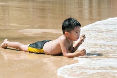 Portrait of shirtless boy in water