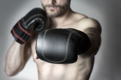 Midsection of athletic boxer against gray background