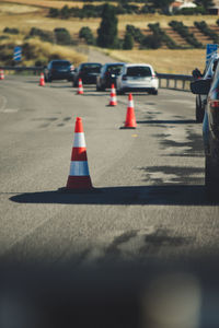 Traffic cones and cars on road during sunny day