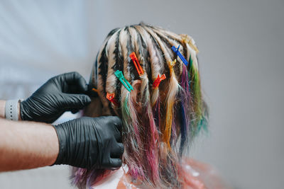 Hairstylist putting clips on hair of woman in salon