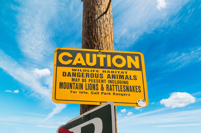 Low angle view of road sign against sky