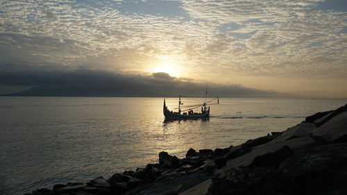 Silhouette boat on sea against sky during sunset