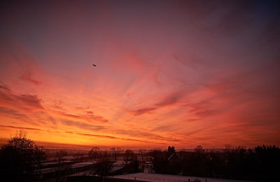 Silhouette of buildings against orange sky