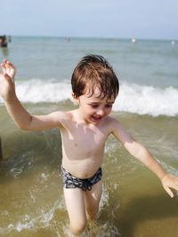 Boy on beach against sky